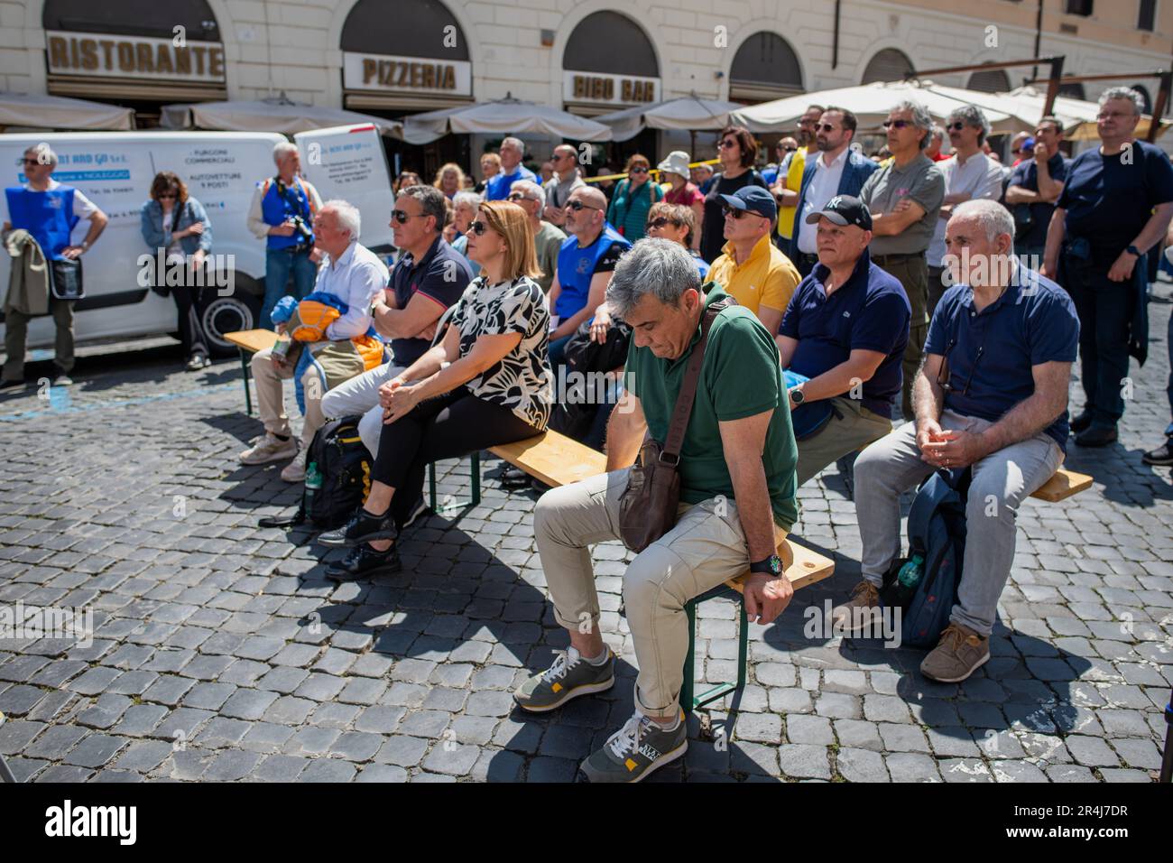 I manifestanti attenti seduti sotto il sole ascoltano i discorsi durante la manifestazione. Manifestazione in Piazza Santi Apostoli organizzata dall’Associazione pensionati polizia di Stato 94° corso Antiochia (Associazione statale pensionati 94th° corso Antiochia) per chiedere la normalizzazione dei coefficienti di trasformazione previsti dalla legge di bilancio 2021, applicata alle pensioni dall’INPS (istituzione nazionale di sicurezza sociale) E renderli uguali a quelli applicati ai membri dell'arma dei Carabinieri o della Brigata dei Vigili del fuoco. Foto Stock