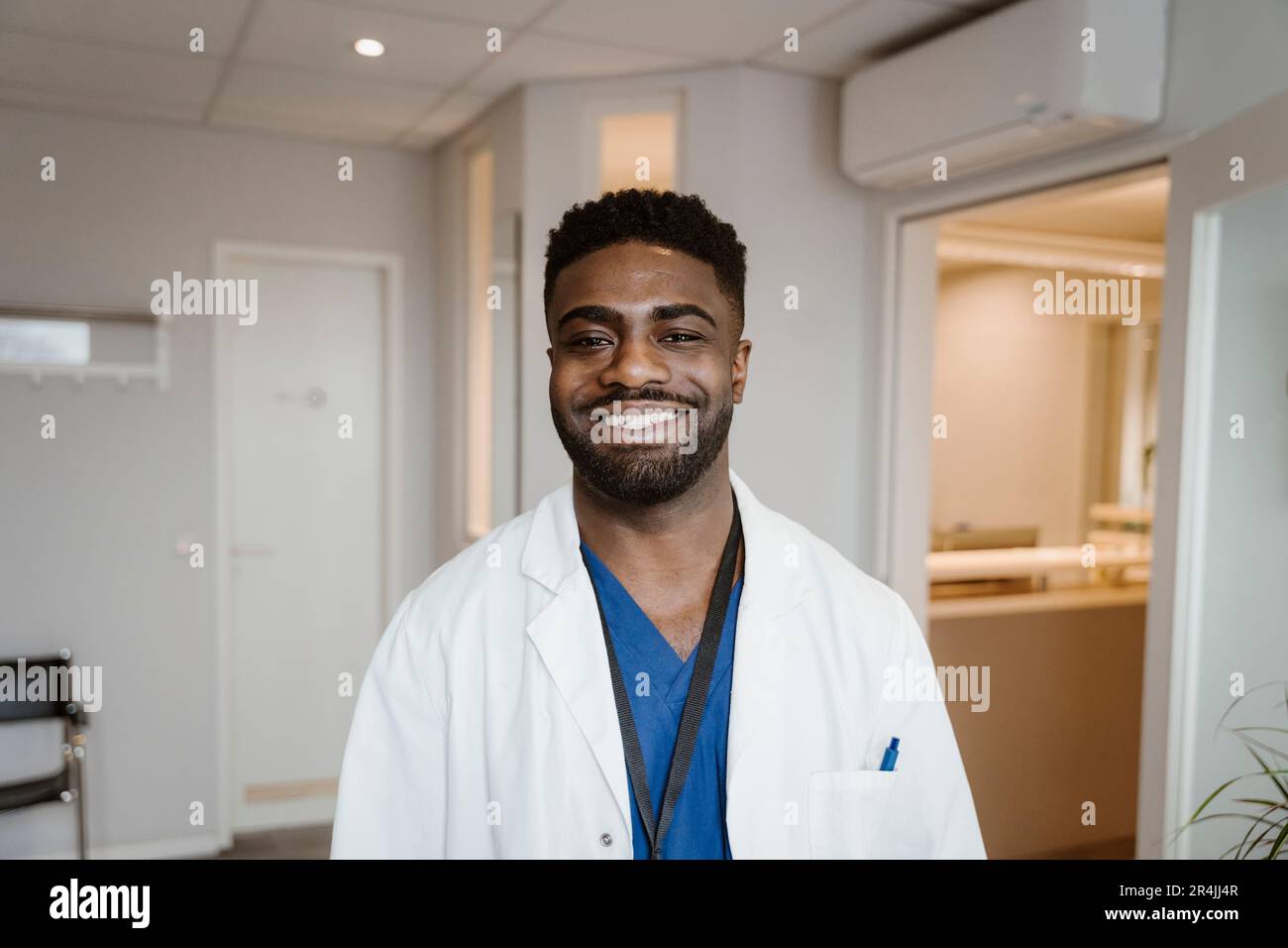 Ritratto di giovane medico sorridente che indossa un camice da laboratorio in ospedale Foto Stock
