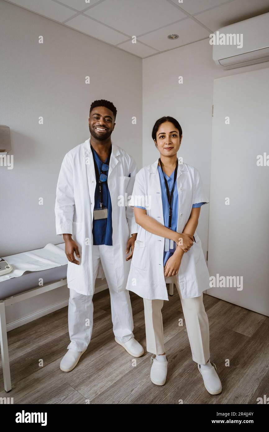 Ritratto di operatori sanitari sicuri di sesso maschile e femminile in piedi nella sala di consulenza Foto Stock