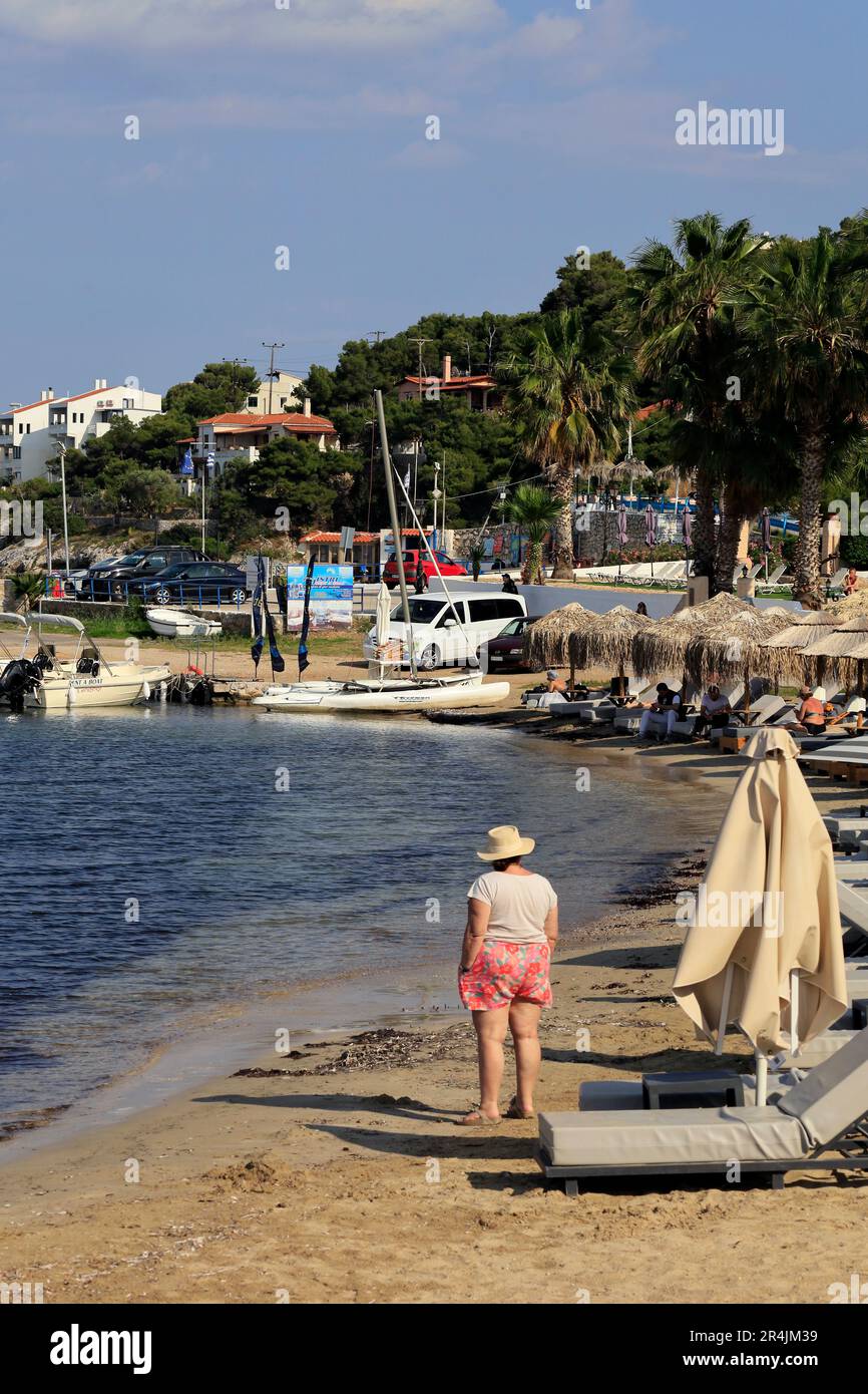 Donna anziana in un cappello da sole sulla spiaggia, Skala, Isola di Agistri, vicino ad Atene. Gruppo di isole Saroniche. Preso maggio 2023 Foto Stock Donna anziana in un cappello da sole sulla spiaggia, Skala, Isola di Agistri, vicino ad Atene. Gruppo di isole Saroniche. Preso maggio 2023 Foto Stock