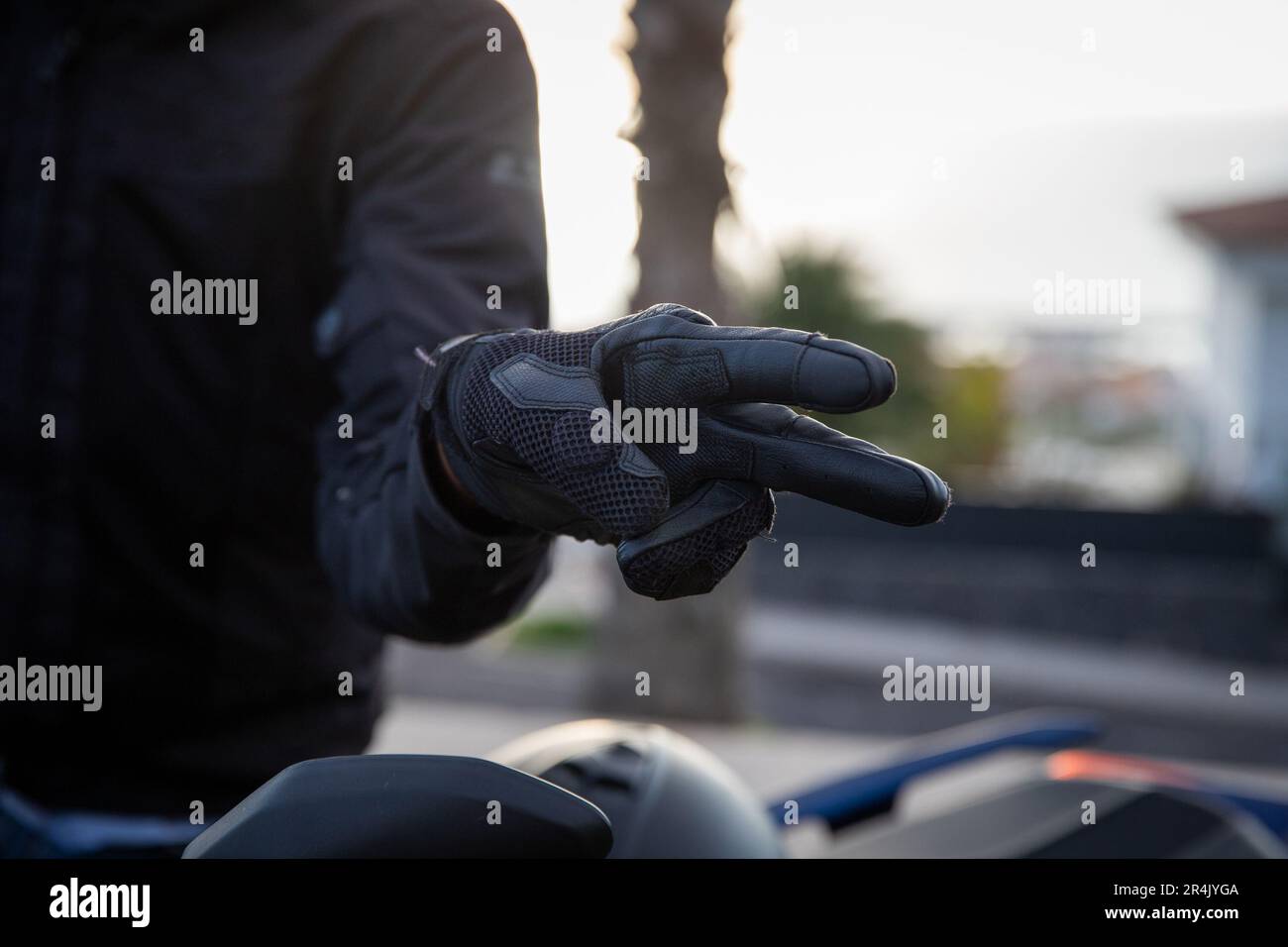 Primo piano delle mani di un ciclista che mostra la mano gestore di saluto, il gesto V. Foto Stock