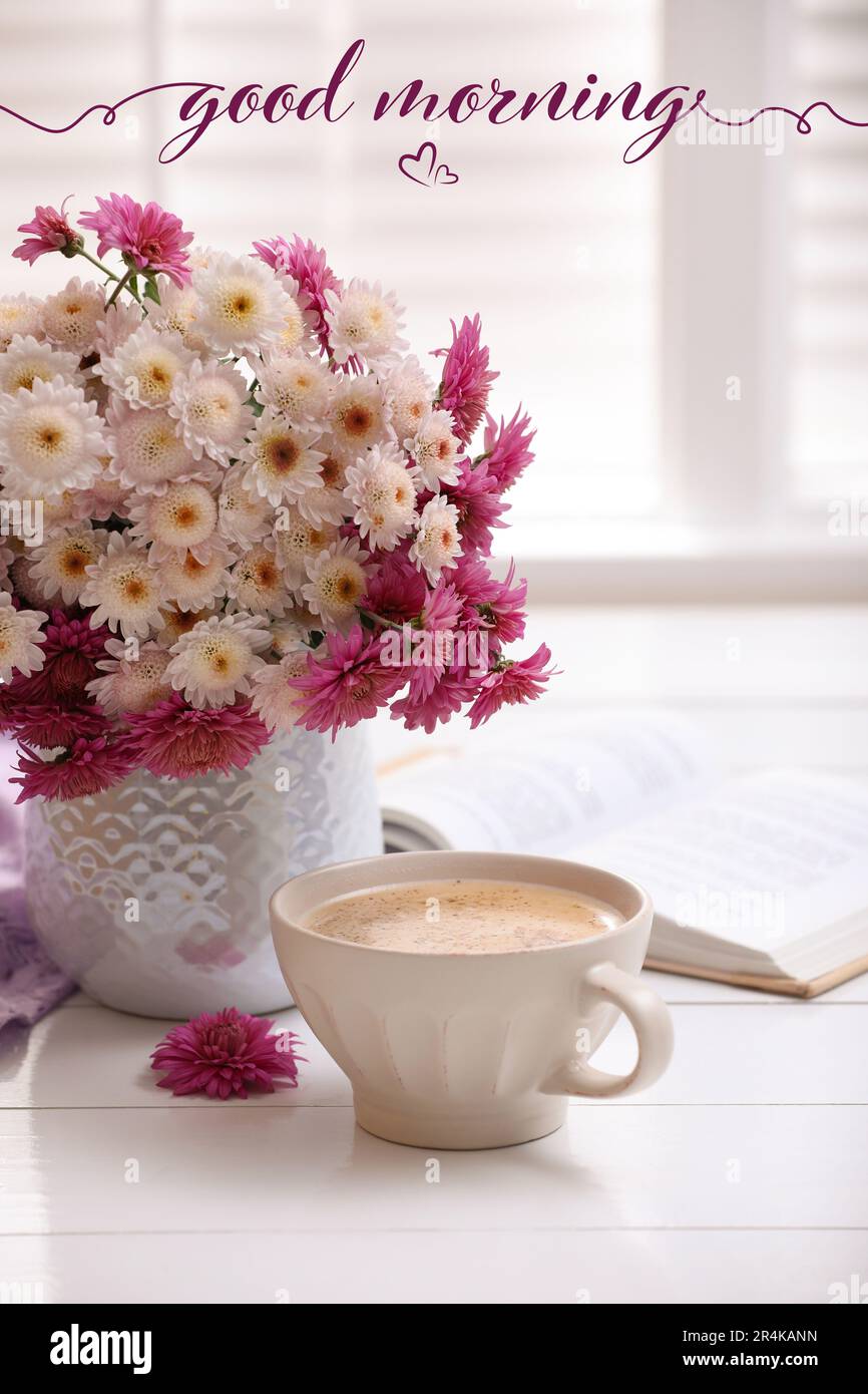Buongiorno! Tazza di caffè fresco, libro aperto e bel bouquet su un tavolo  di legno bianco vicino alla finestra Foto stock - Alamy