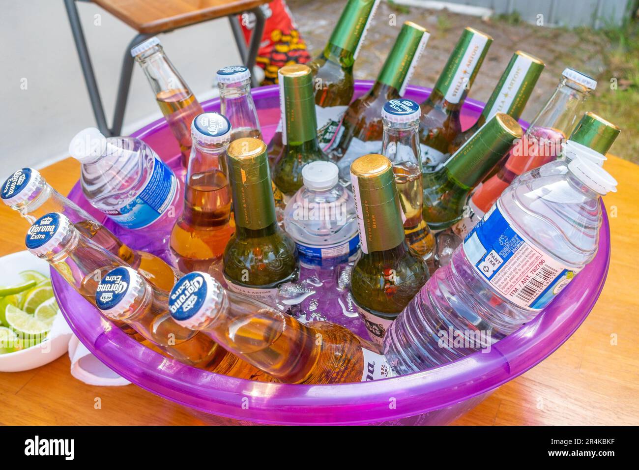Una ciotola piena di bottiglie di prevalentemente birra con acqua e vale a dire per mantenere fresco. Foto Stock
