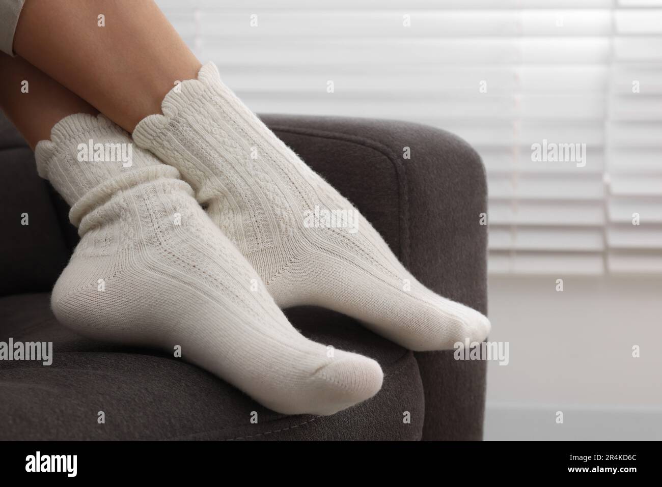 Donna in calze calde relax su poltrona a casa, primo piano. Spazio per il testo Foto Stock
