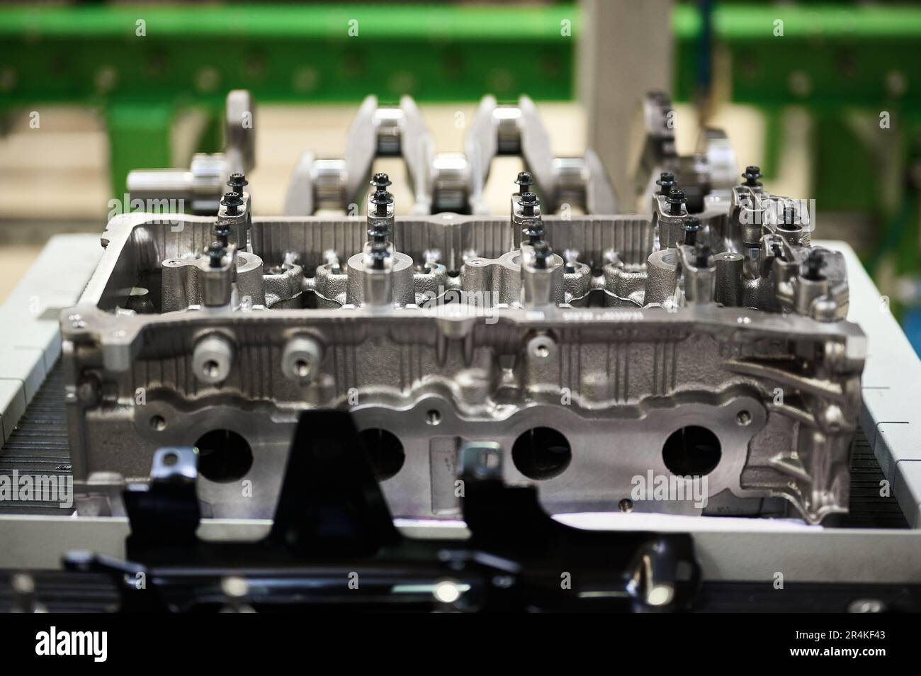 Testa cilindro del motore sfocata contro l'albero motore sul convogliatore Foto Stock
