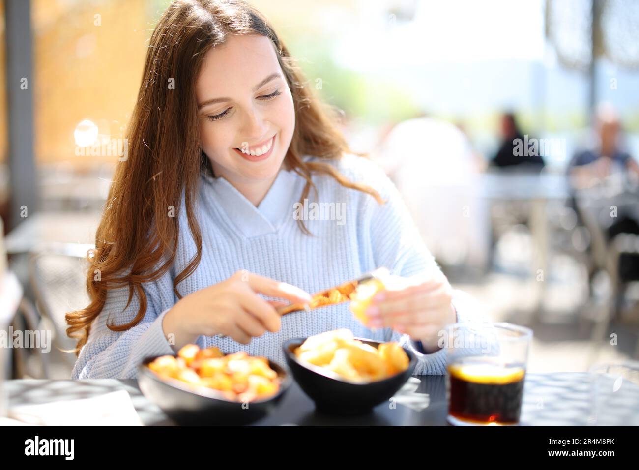 Donna che spreme un limone su cibo seduto in un ristorante Foto Stock