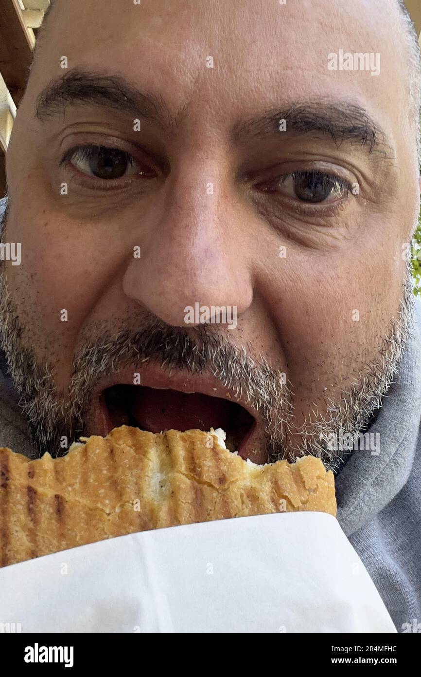 Uomo di mangiare un panino Foto Stock