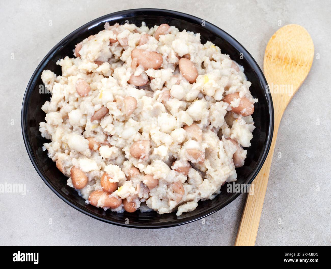 Fiocco sudafricano, samp e fagioli in grigio chiazzato con cucchiaio di legno Foto Stock