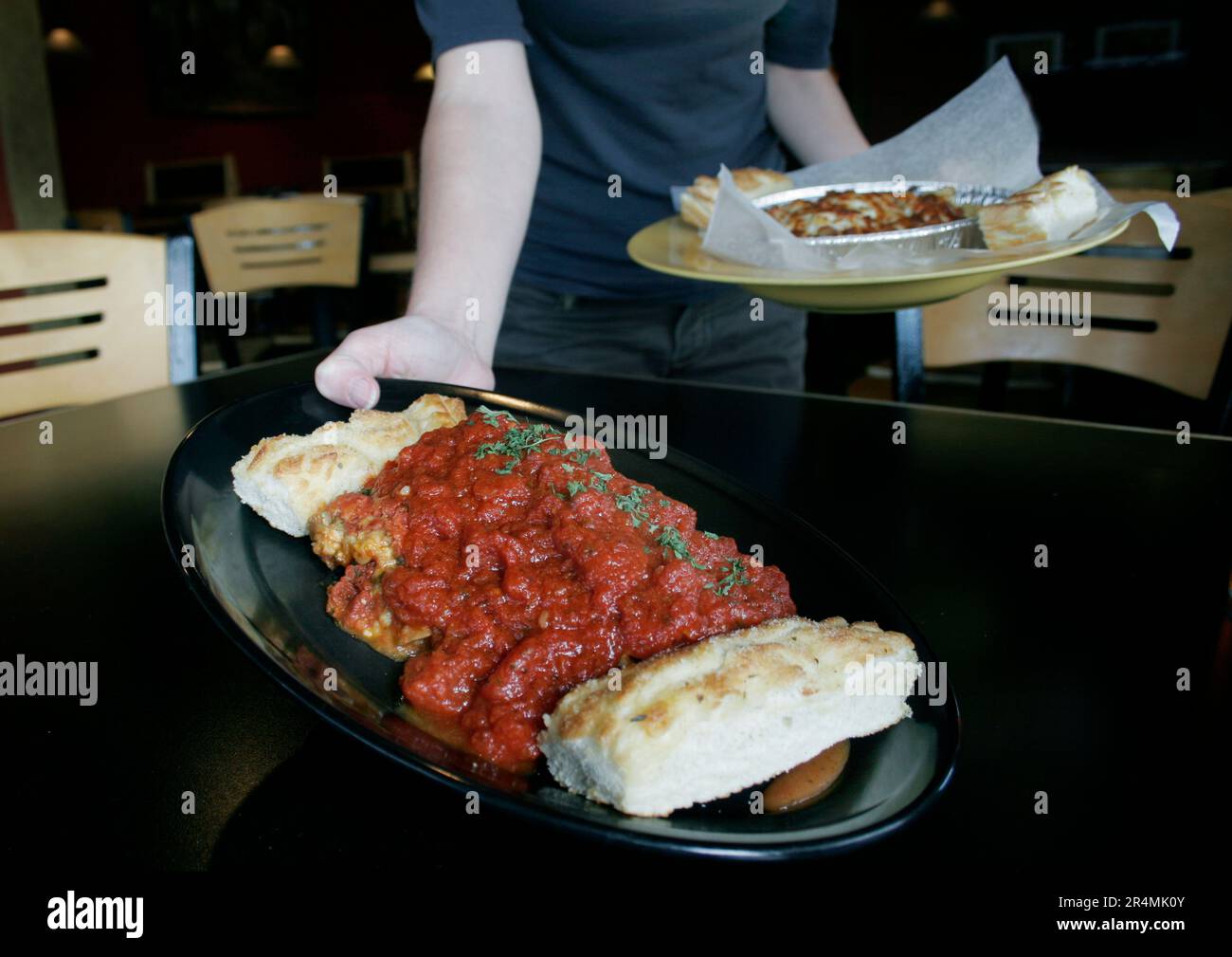 Una cameriera serve cibo ai clienti ad un tavolo in un ristorante italiano a Nashville, Tennessee. Foto Stock