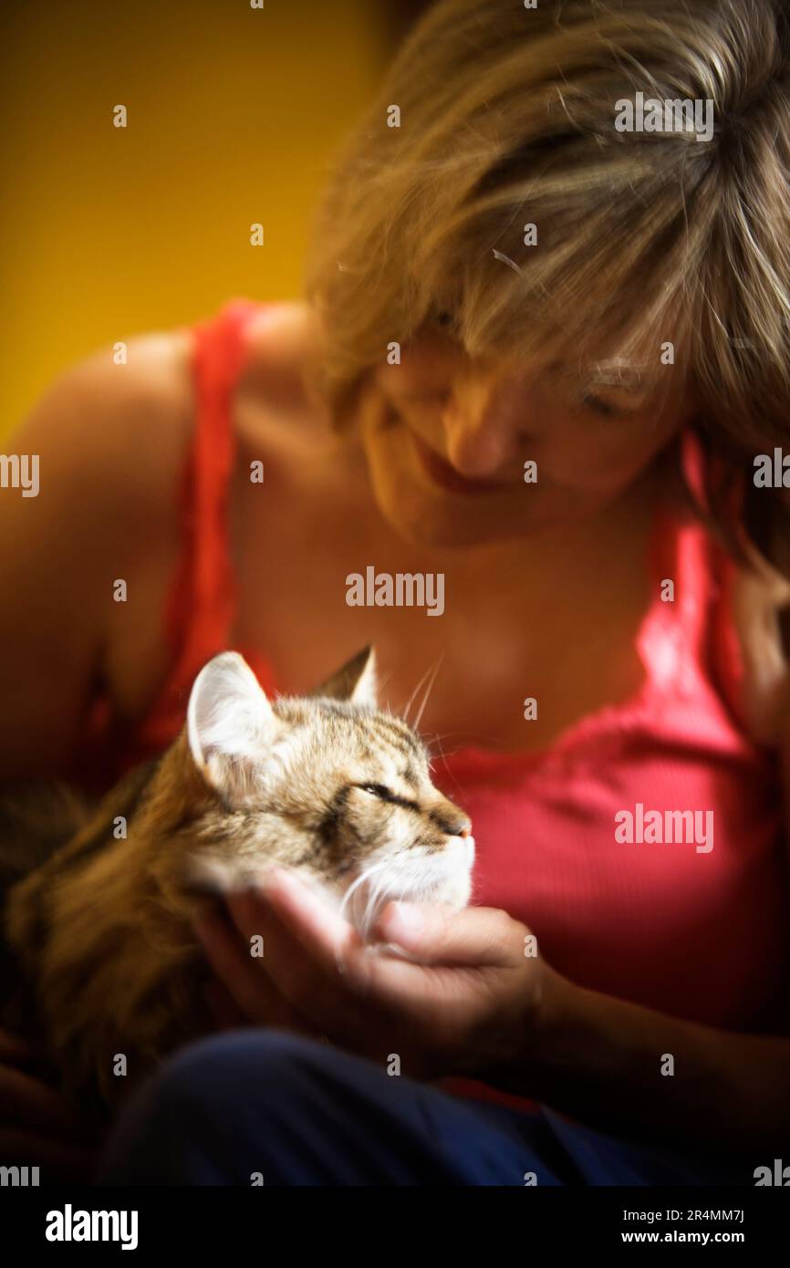Una donna che tiene amorevolmente il suo gatto. Foto Stock