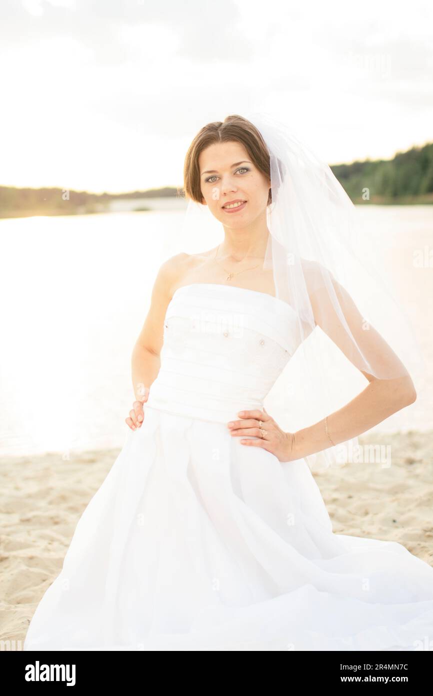 Ritratto di sposa in piedi sulla spiaggia in estate Foto Stock