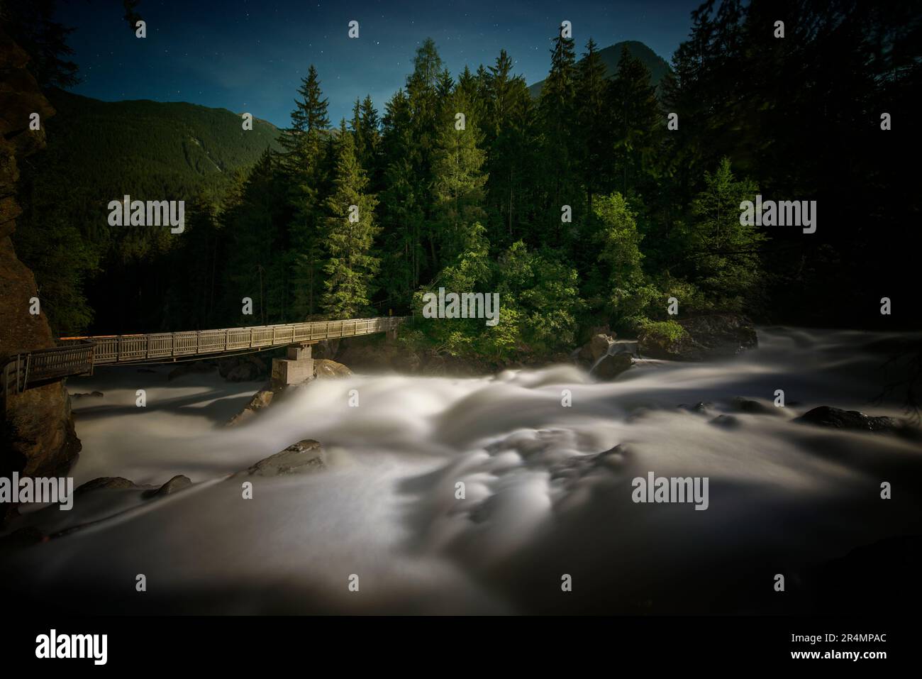 Foto a lunga esposizione di Wood Bridge e acqua bianca al chiaro di luna Foto Stock