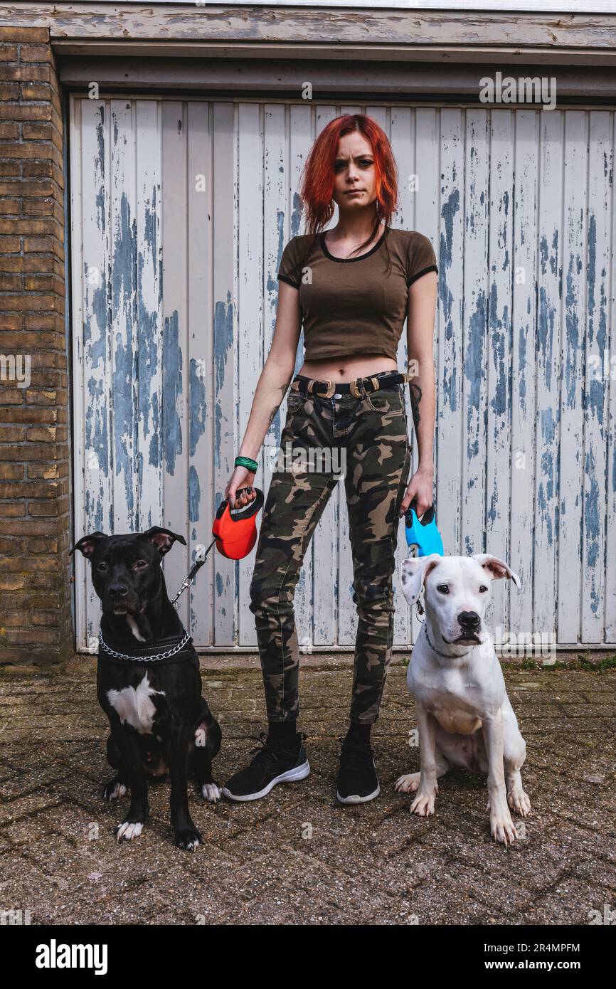 Donna con i suoi due cuccioli grandi in una passeggiata Foto Stock