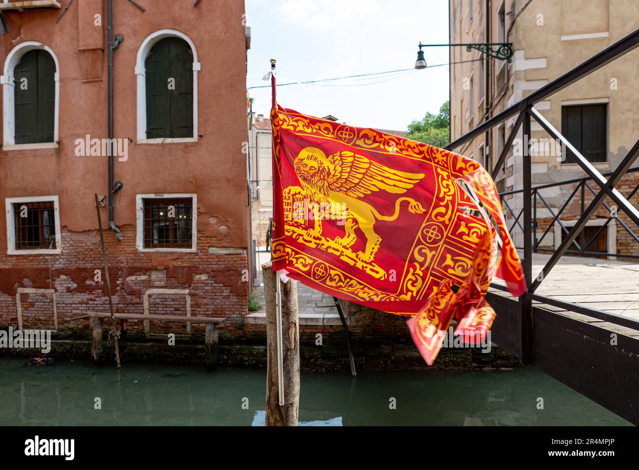 Bandiera veneziana che sventola su un canale a Venezia Foto Stock