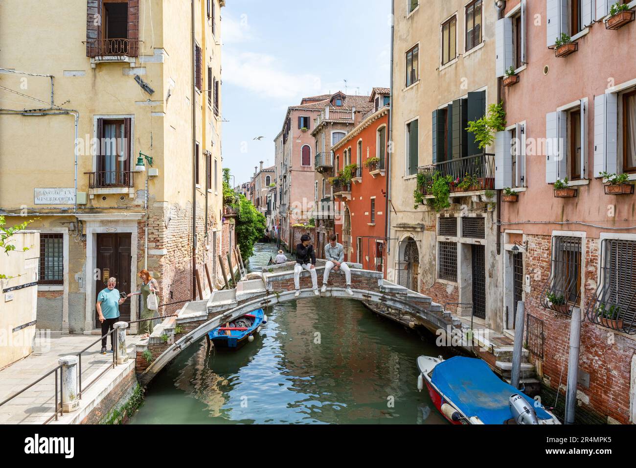 Due giovani seduti a Ponte Chiodo, Venezia Foto Stock