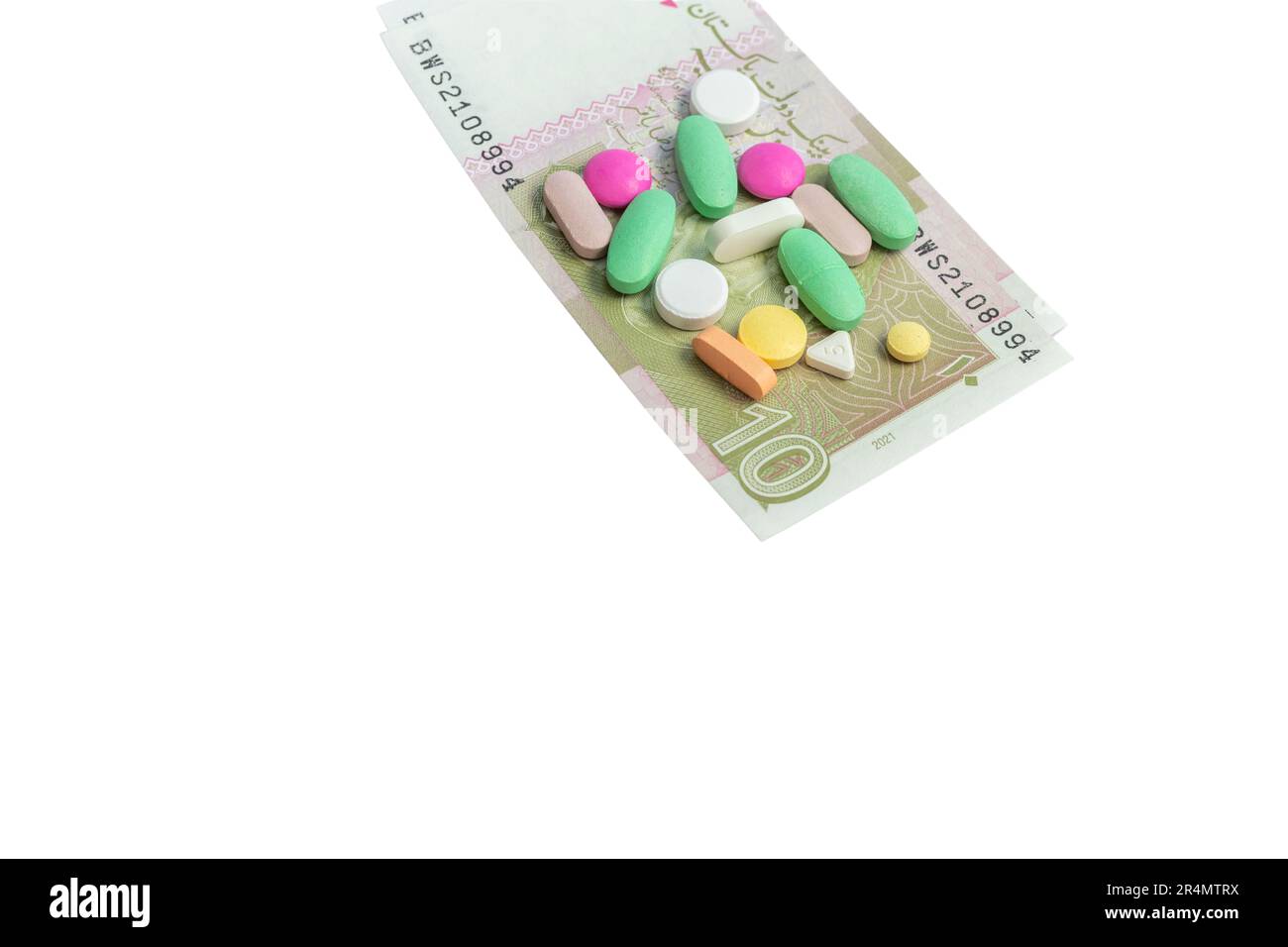 Pillole con un Pakistan dieci rupie note isolato su sfondo bianco. Costo di acquisto di droga concetto. Foto Stock