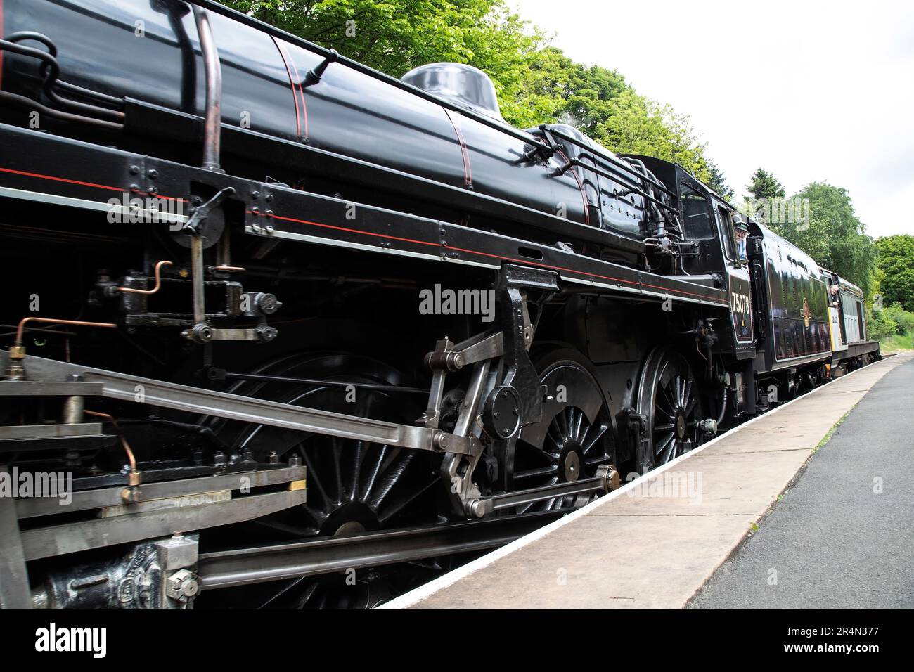 Una vista a livello della piattaforma della locomotiva a vapore 75078 BR Standard Class 4mt 4-6-0 che arriva alla stazione di Oxenhope sulla ferrovia di Keighley & Worth Valley Foto Stock