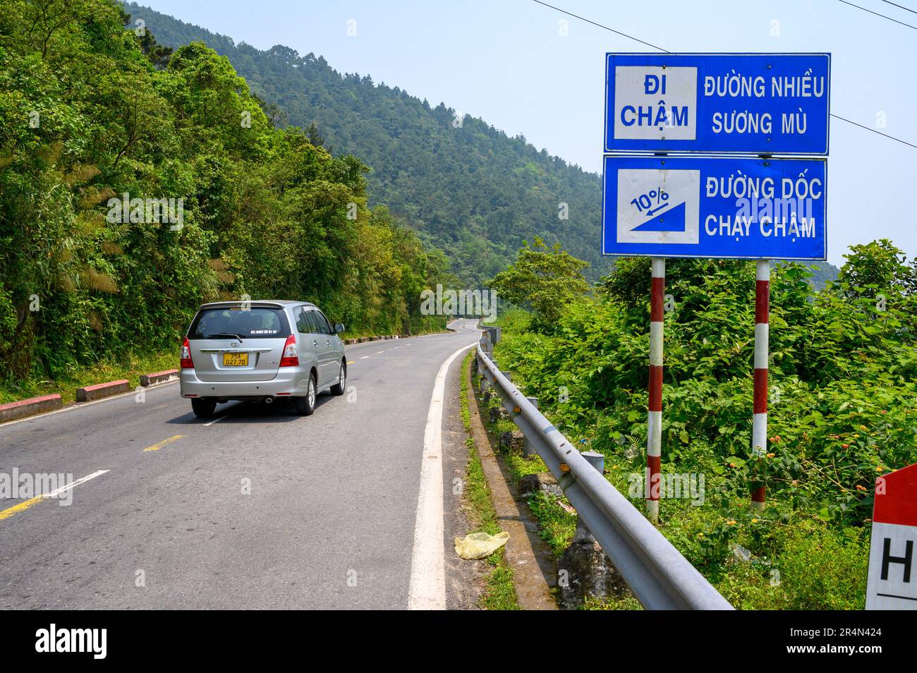 Una macchina guida lungo la strada National Route 1 a Hai Van Pass, Vietnam. Foto Stock