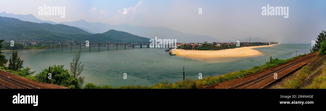 Vista panoramica sul villaggio di Lang Co, la laguna, il ponte e le piste ferroviarie dal punto di vista della National Route 1 sul passo Hai Van, Vietnam. Foto Stock