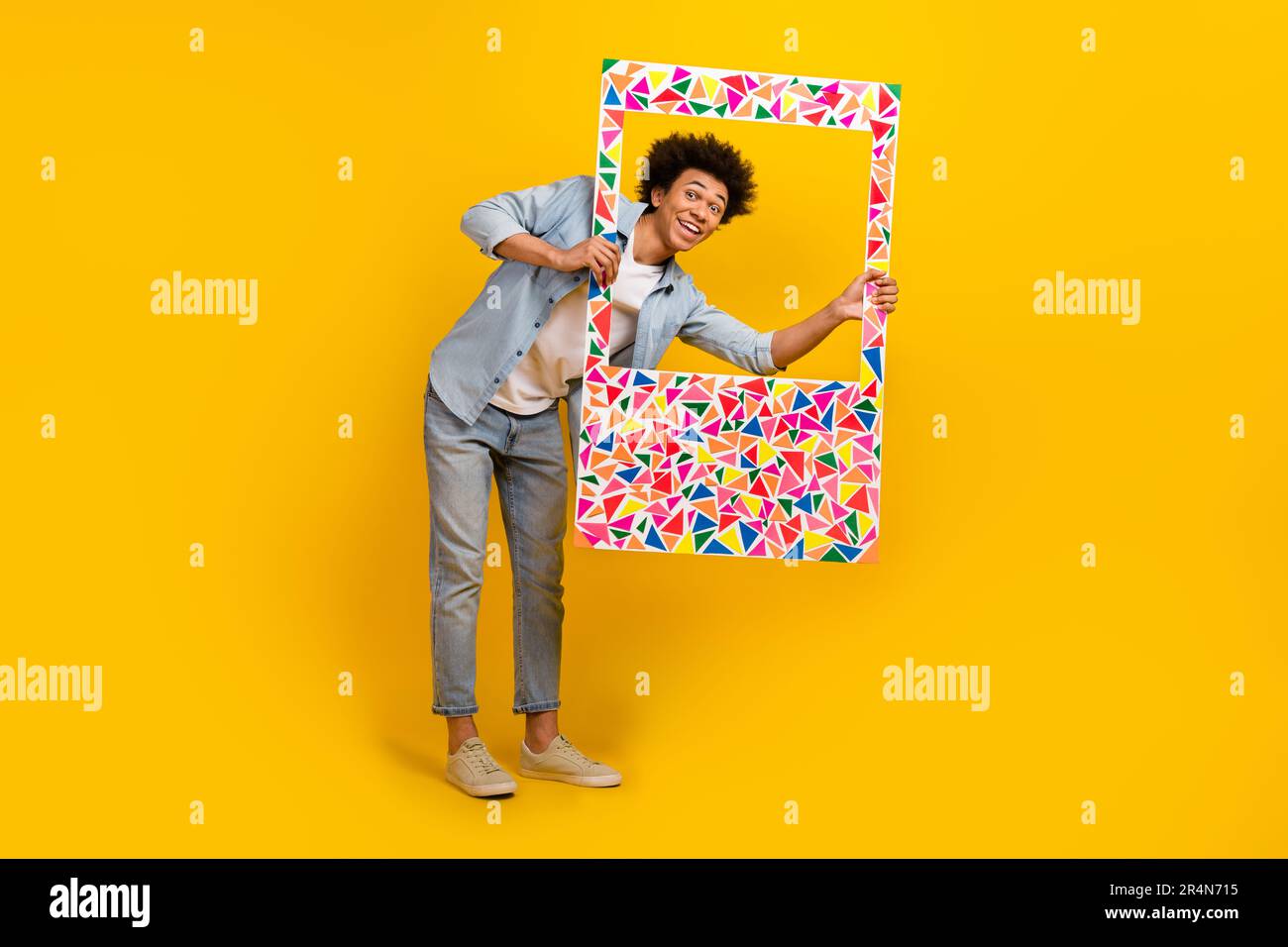 Foto a dimensione intera di persone positive braccia tenere guardare attraverso carta album scheda isolato su sfondo giallo Foto Stock