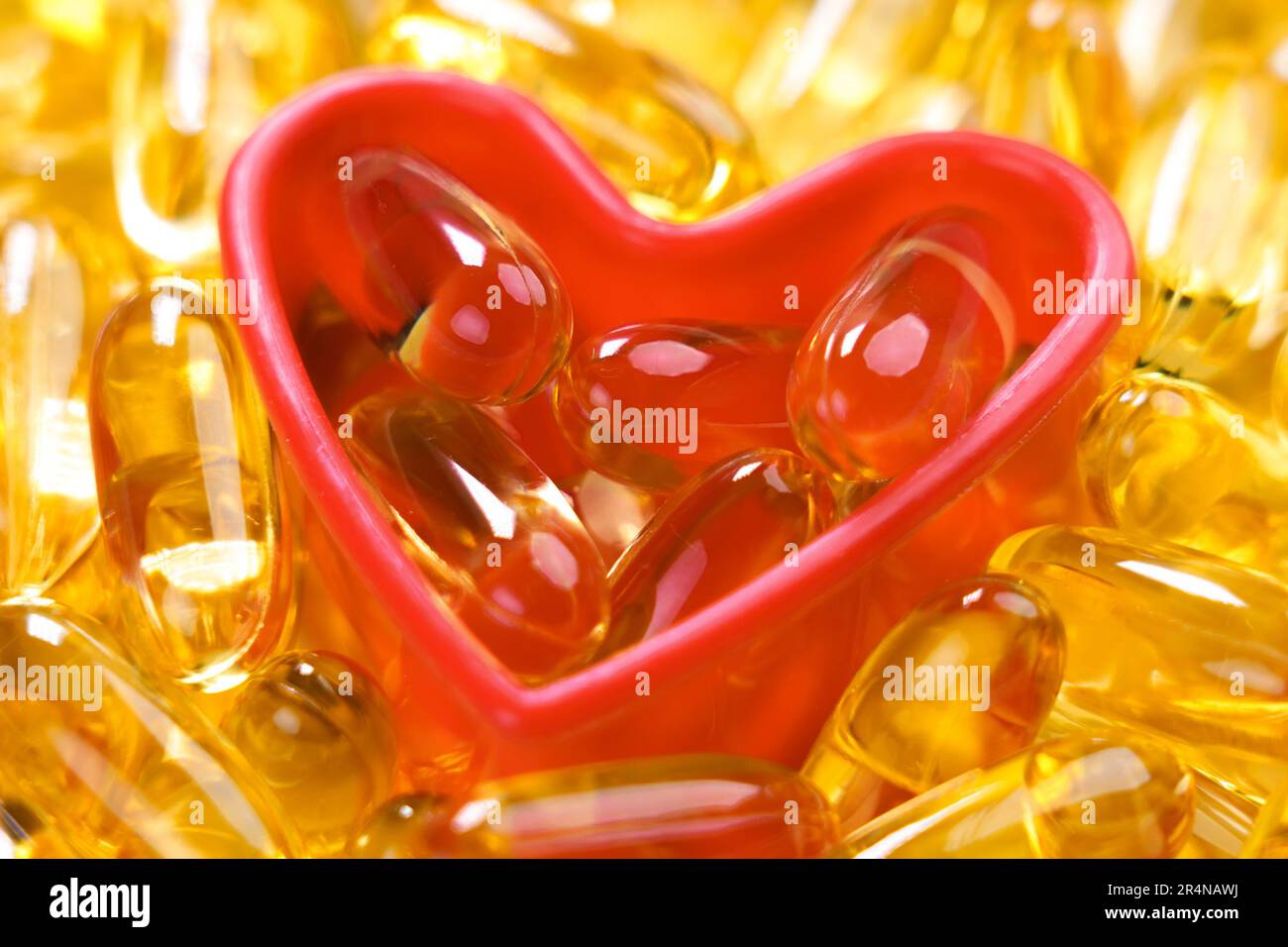 Integratore nutriente Omega 3 capsule in un primo piano a forma di cuore di plastica Foto Stock