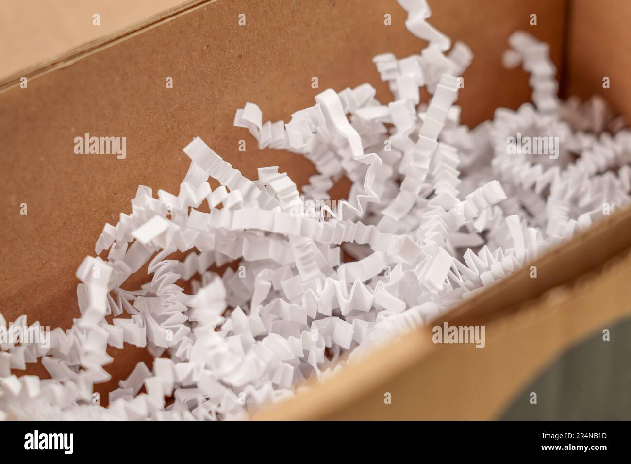 Aprire la scatola di cartone con il riempitivo in plastica grattugiato bianco da vicino Foto Stock