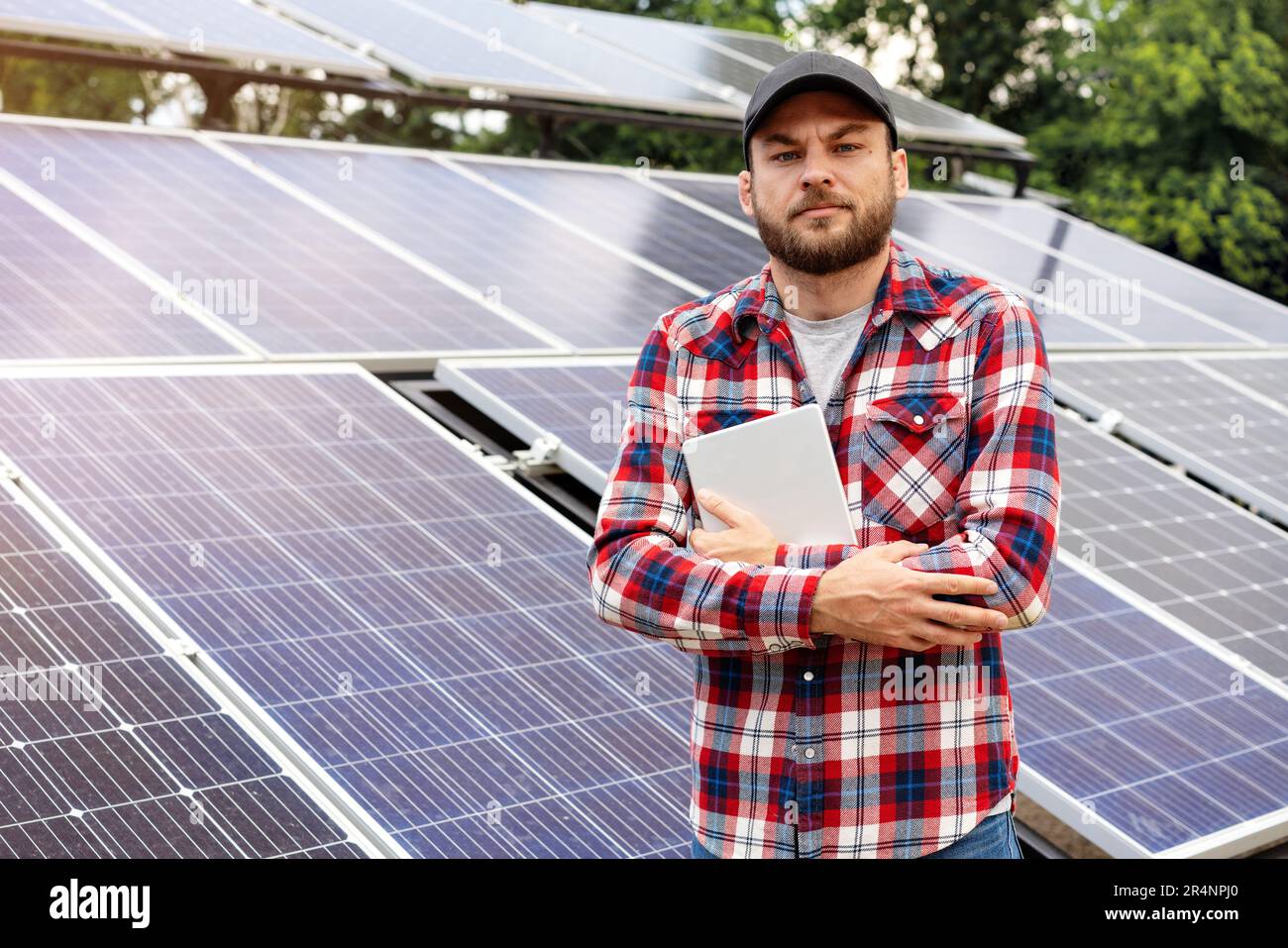 Ritratto di campo ispettore di stazioni di energia solare, uomo con tablet digitale contro pannelli solari. Foto Stock