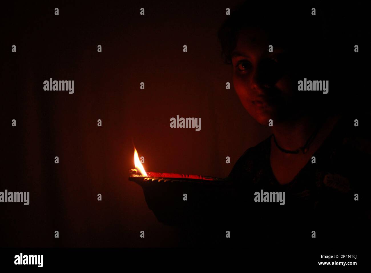 Giovane ragazza teenage indiana che tiene Diwali Clay lampada ad olio Foto Stock
