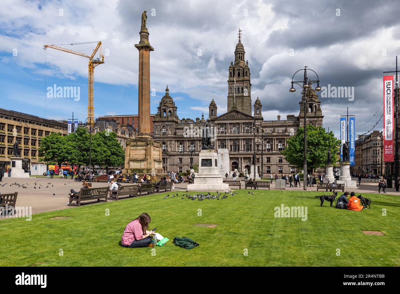 The George Square nel centro di Glasgow, in Scozia, Regno Unito. Glasgow City Chambers, Scott Monument e persone che visitano e si rilassano Foto Stock