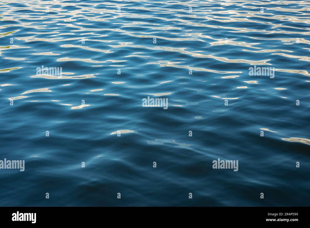 Splendidi motivi ondulati e riflessi nell'acqua blu del mare. Adatto per sfondo o sfondo. Foto Stock