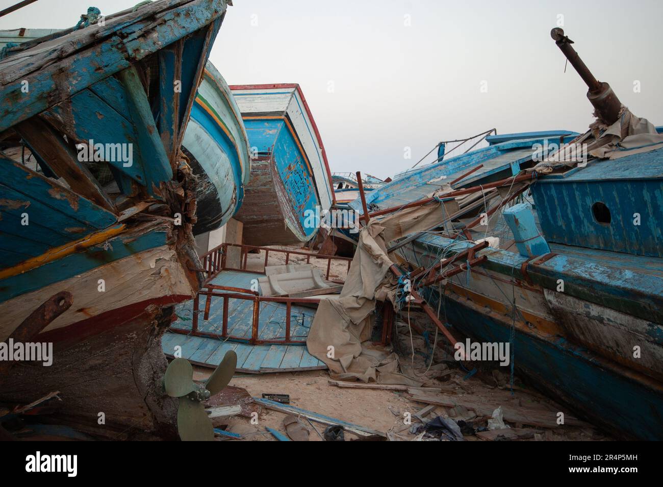 Imbarcazioni migranti abbandonate che sono state trasportate all'interno dalle autorità italiane sull'isola di Lampedusa. Molti hanno nomi arabi dipinti su di loro Foto Stock