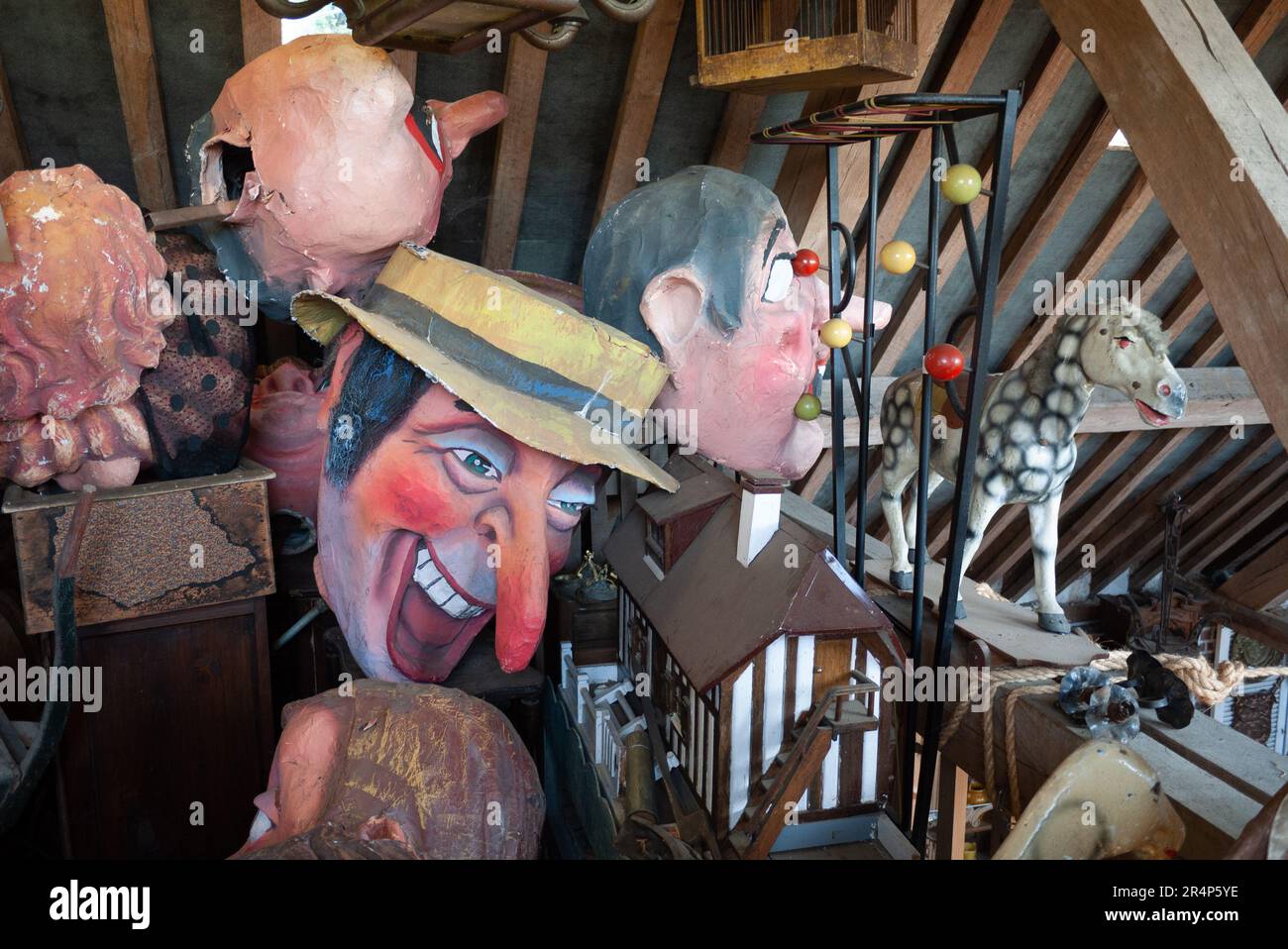 Una collezione di volti funfare e maschere in un magazzino antico, Rouen Francia Foto Stock