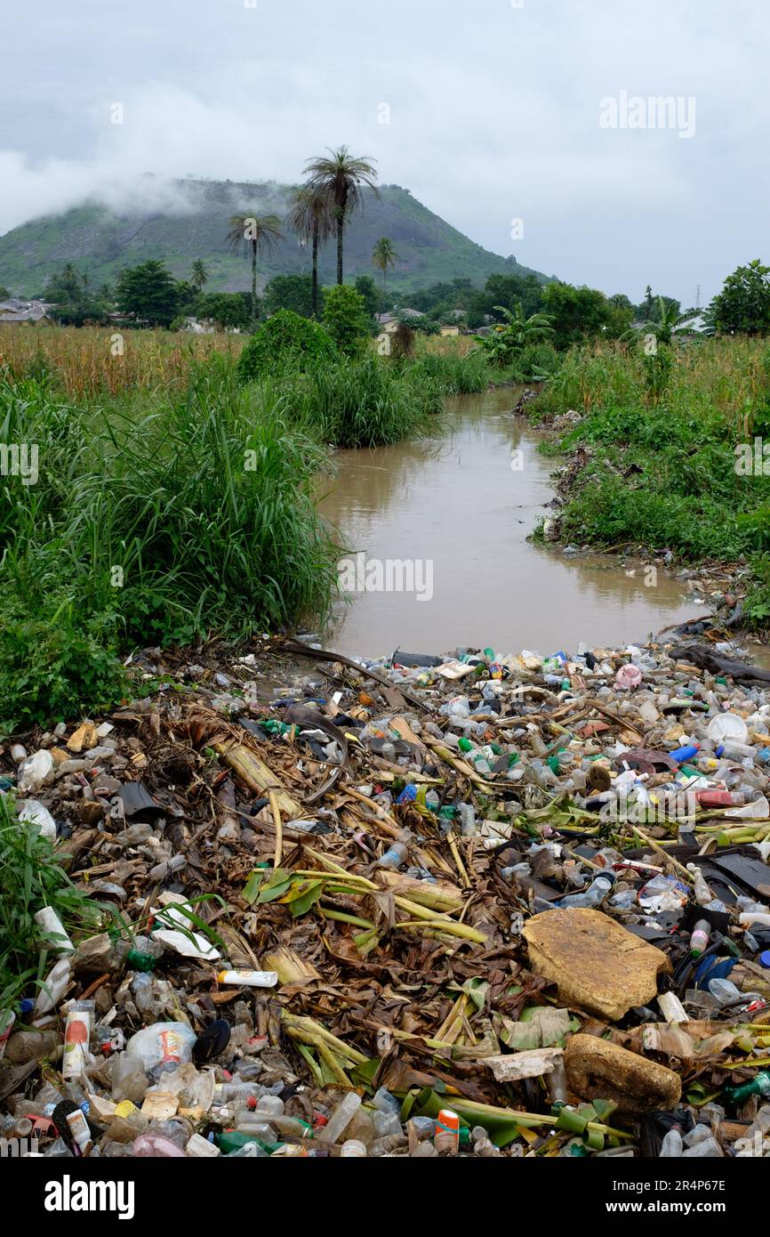 Spazzatura e plastica mista scartata che galleggia su un ruscello a Makeni, Sierra Leone Foto Stock