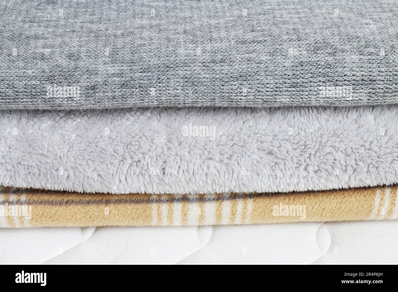 Tre coperte: Grigio e beige sul materasso. Risorse grafiche Foto Stock