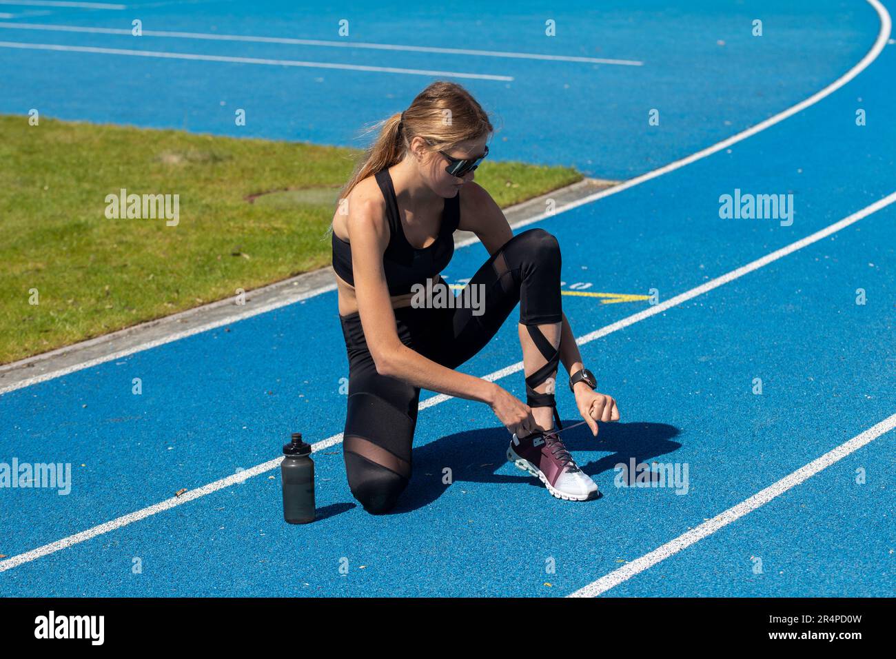 Giovane atleta femminile e atleta di campo su una pista blu tartan (immagine simbolo, modello rilasciato) Foto Stock