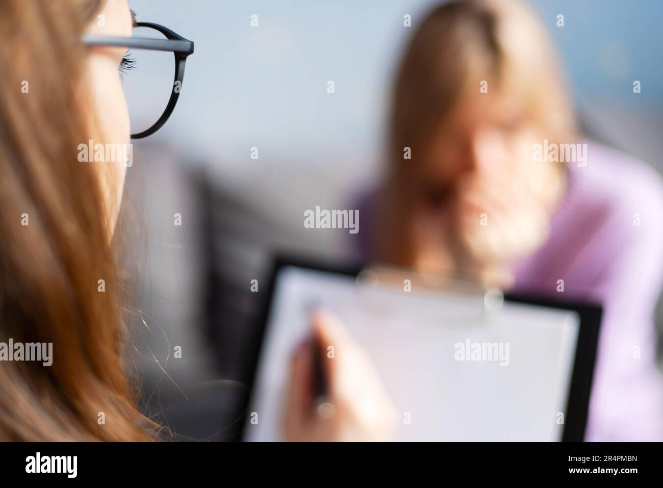 Sessione di psicoterapia, una donna sta parlando con la sua psicologa in ufficio accogliente Foto Stock
