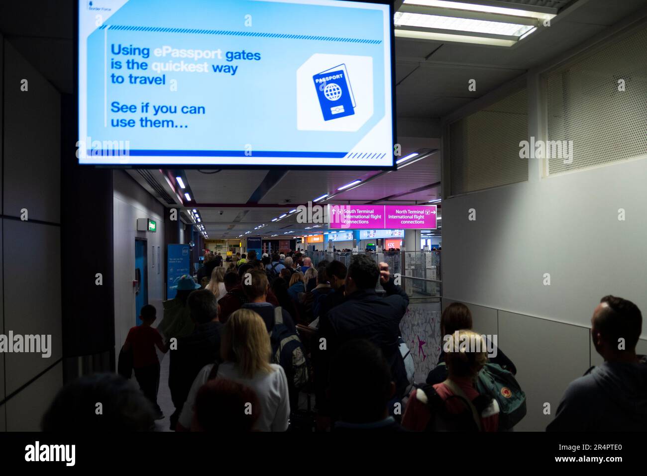 Lunghe code di passeggeri ritardate dal fallimento dei cancelli automatici dell'aeroporto Gatwick di Londra, Regno Unito. Firma per promuovere la velocità di utilizzo di un ePassport Foto Stock