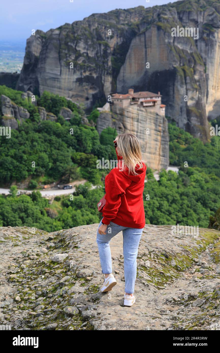 Donna in un maglione rosso gode la natura sulle montagne vicino ai monasteri di Meteora in Grecia Foto Stock
