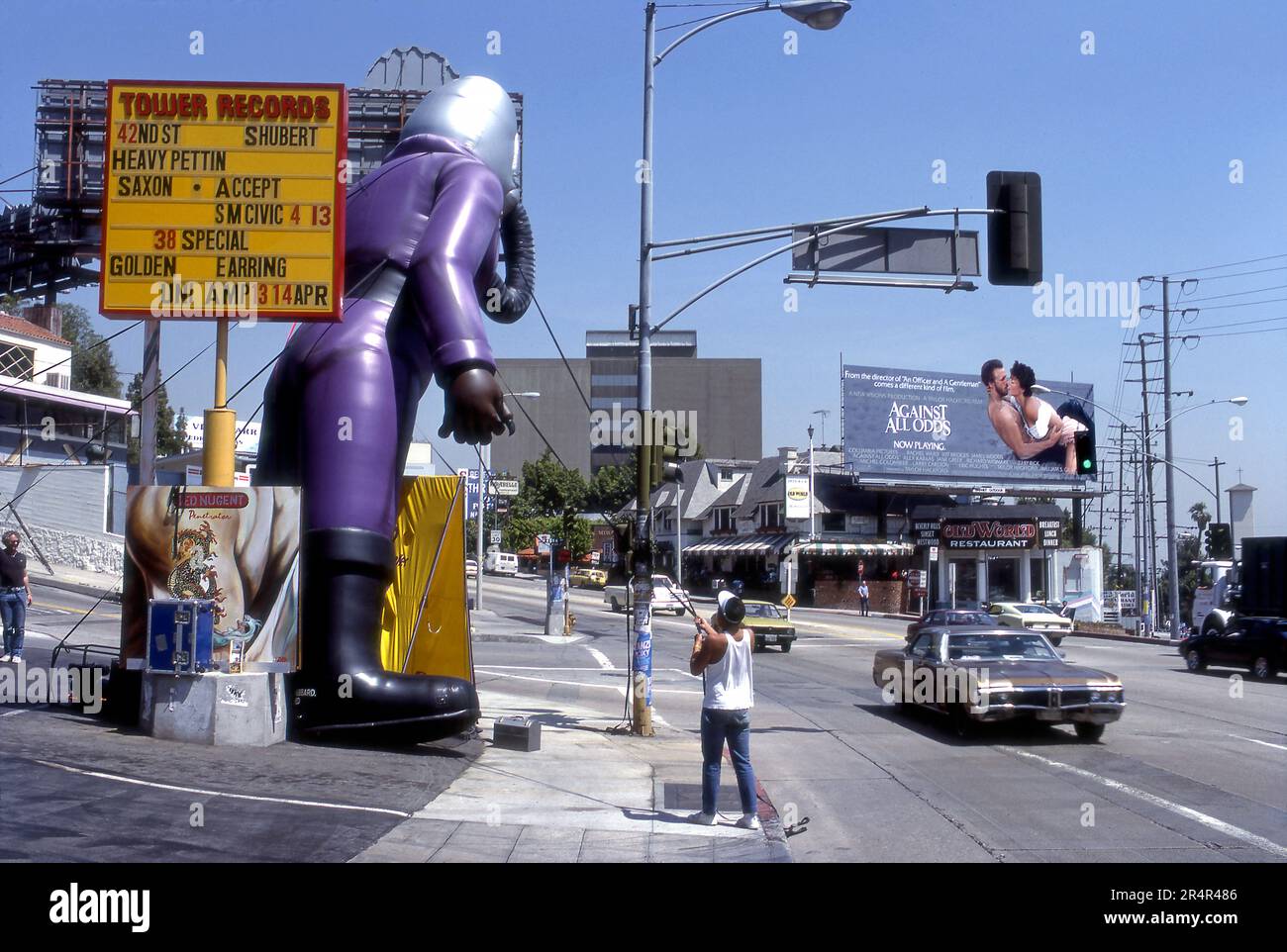 Operaio che installa una grande figura di palloncino pubblicitario alla Tower Records sulla Sunset Strip a Los Angeles, California, 1984 Foto Stock