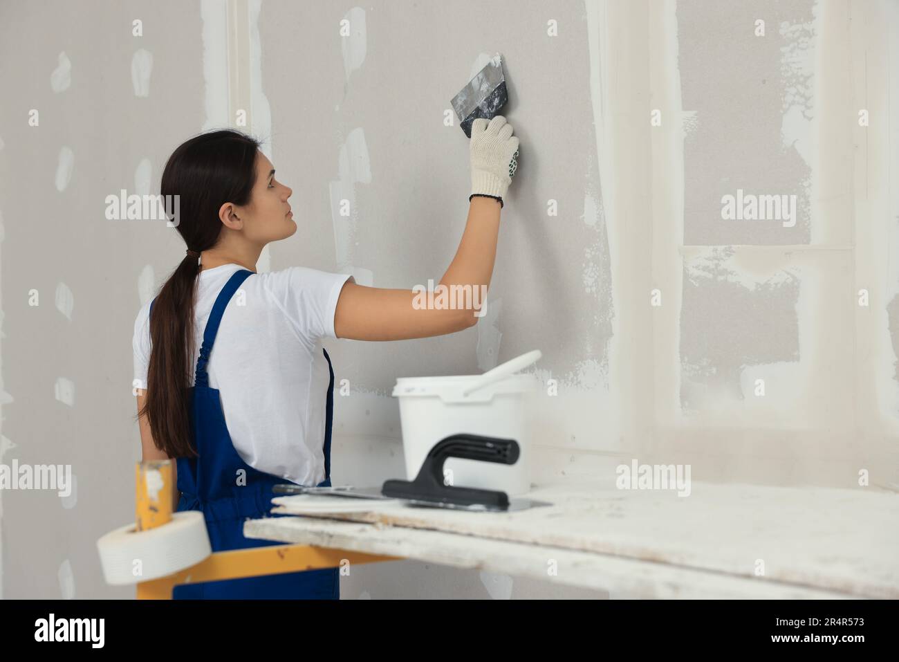 Parete di intonaco del lavoratore con il coltello dello stucco all'interno  Foto stock - Alamy