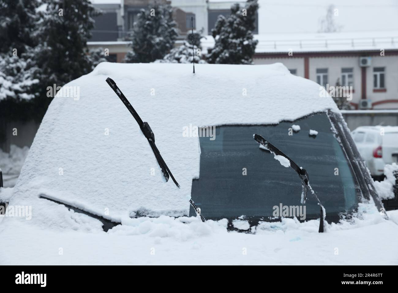 Auto con tergicristalli coperti di neve all'aperto nei giorni invernali Foto Stock