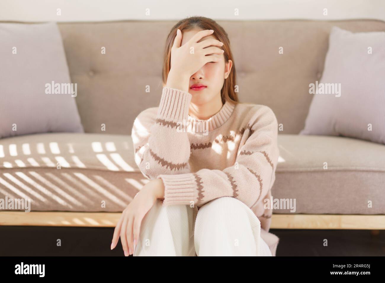 Concetto di tempo di riposo, le donne sono sedute sul pavimento e toccare la fronte dolorante con mal di testa sofferenza. Foto Stock
