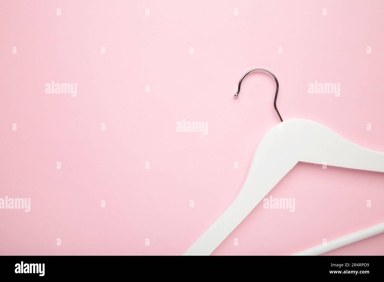 Un appendiabiti bianco in legno su sfondo rosa. Concetto di negozio, gancio vuoto. Foto Stock