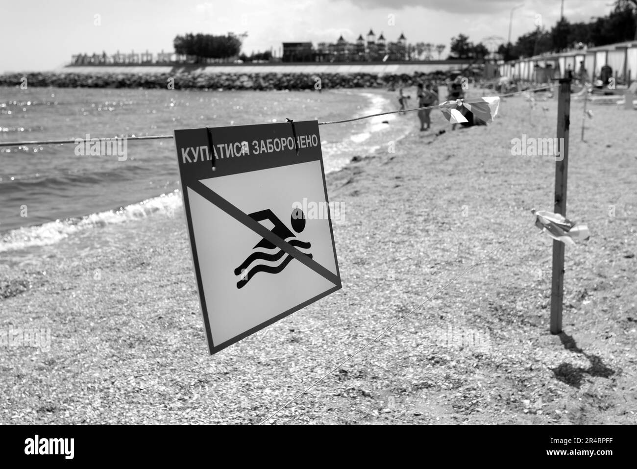 Cartello rosso brillante "No Swimming" sulla spiaggia di sabbia marina della città di Odessa durante l'attacco della Russia all'Ucraina. È vietato nuotare! Avvicinarsi all'acqua è Foto Stock