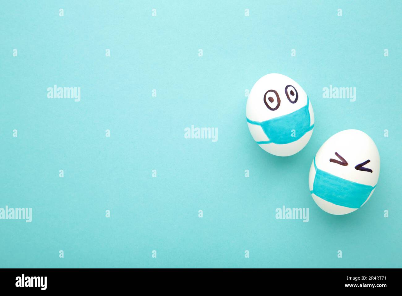 Uova bianche di Pasqua in maschera medica protettiva su sfondo blu. Pasqua sul concetto di quarantena con posto per il testo. Arrestare IL VIRUS COVID-19. Spazio di copia. Ad es Foto Stock