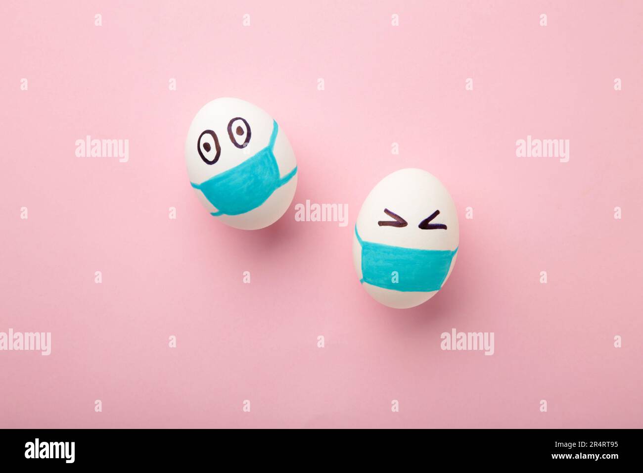 Uova bianche di Pasqua in maschera medica protettiva su sfondo rosa. Pasqua sul concetto di quarantena con posto per il testo. Arrestare IL VIRUS COVID-19. Spazio di copia. Ad es Foto Stock