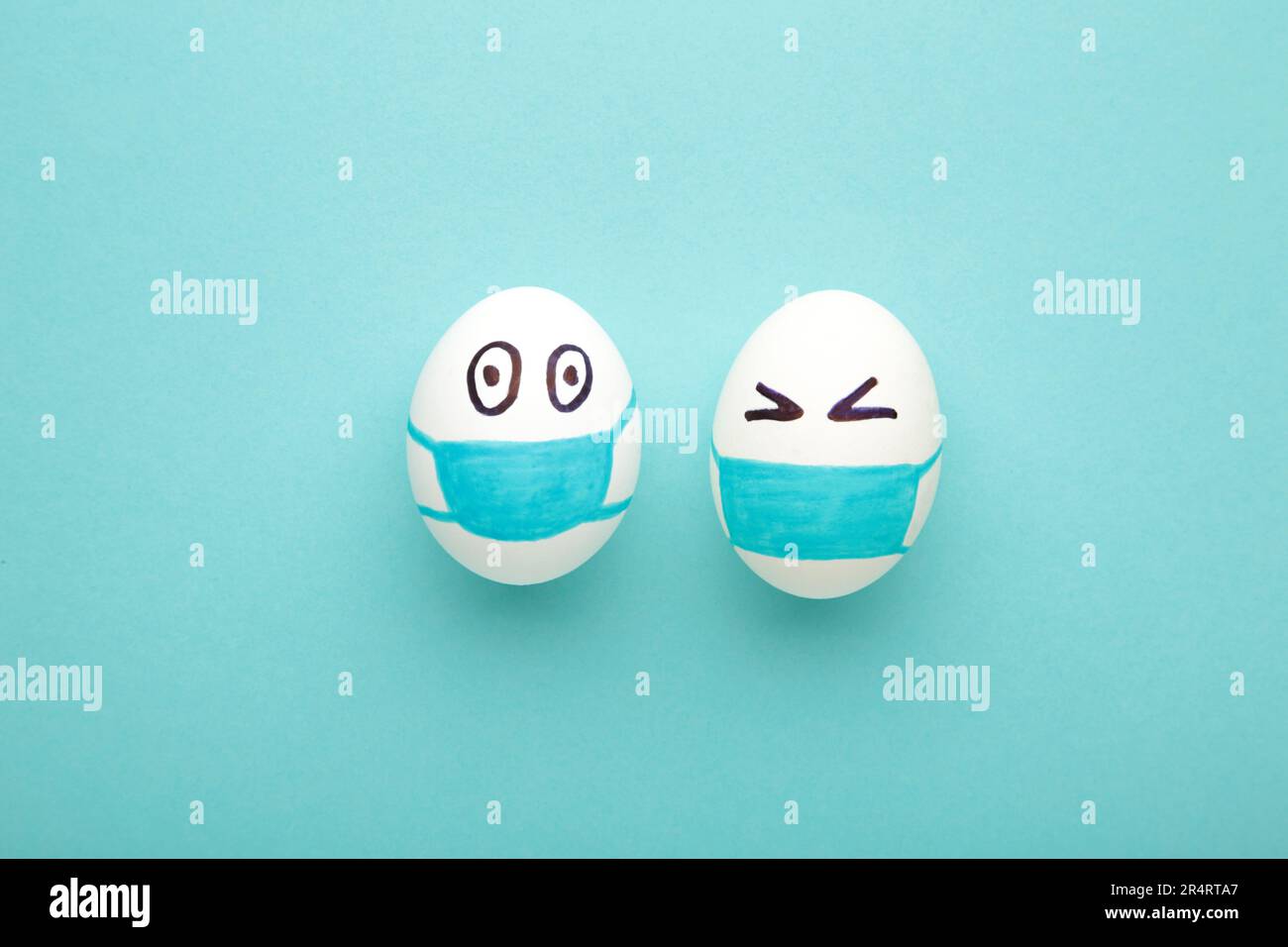 Uova bianche di Pasqua in maschera medica protettiva su sfondo blu. Pasqua sul concetto di quarantena con posto per il testo. Arrestare IL VIRUS COVID-19. Spazio di copia. Ad es Foto Stock