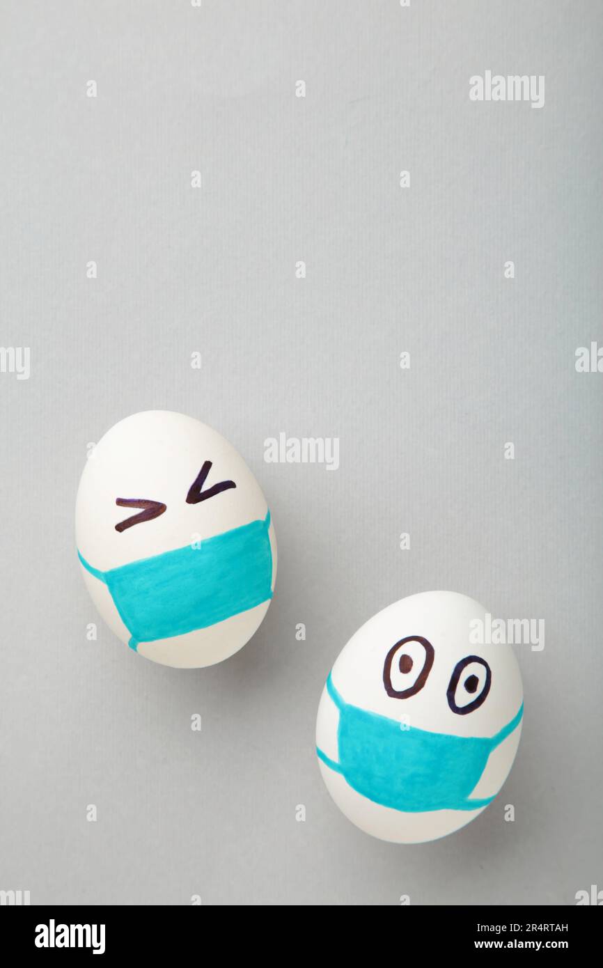 Uova bianche di Pasqua in maschera medica protettiva su sfondo grigio. Pasqua sul concetto di quarantena con posto per il testo. Arrestare IL VIRUS COVID-19. Spazio di copia. Ad es Foto Stock