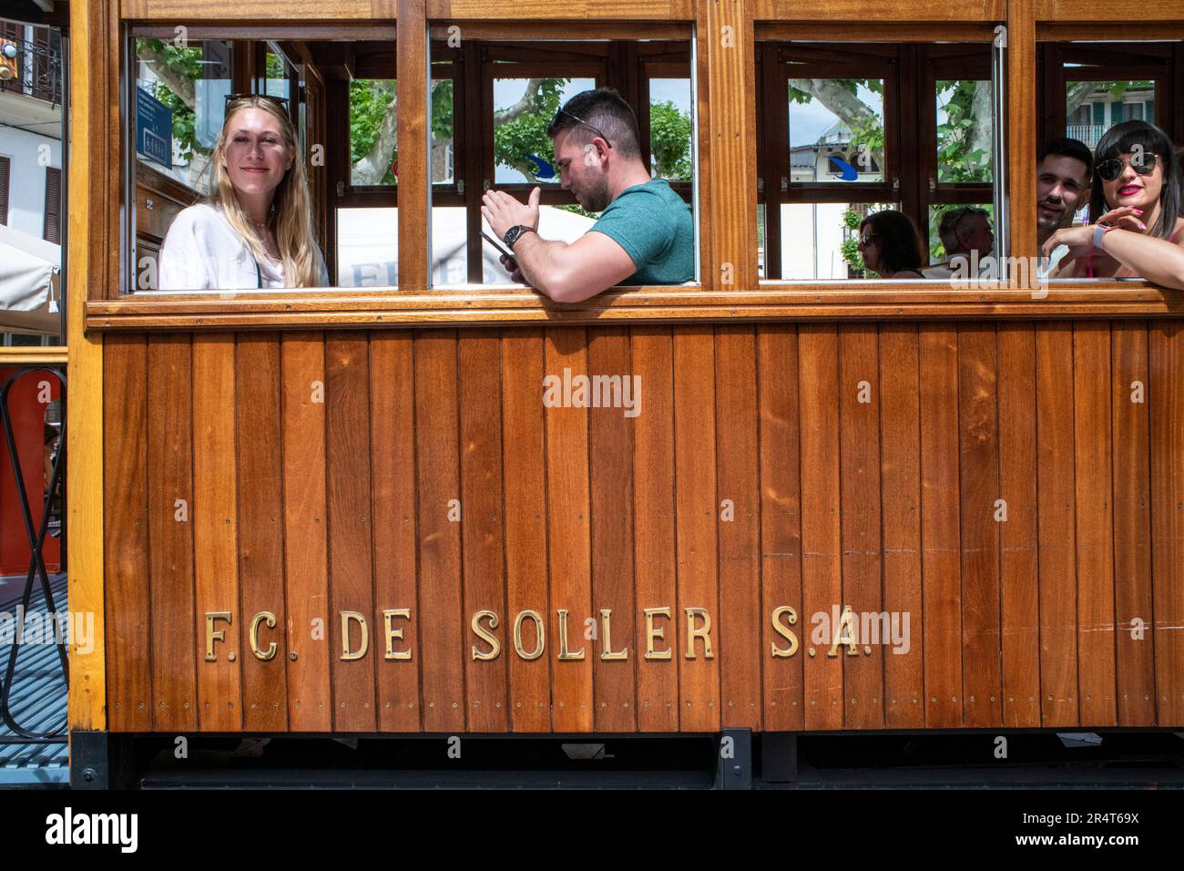 Turisti all'interno del tram d'epoca al centro del villaggio di Soller. Il tram opera un servizio 5kms dalla stazione ferroviaria nel villaggio di Soller al Foto Stock