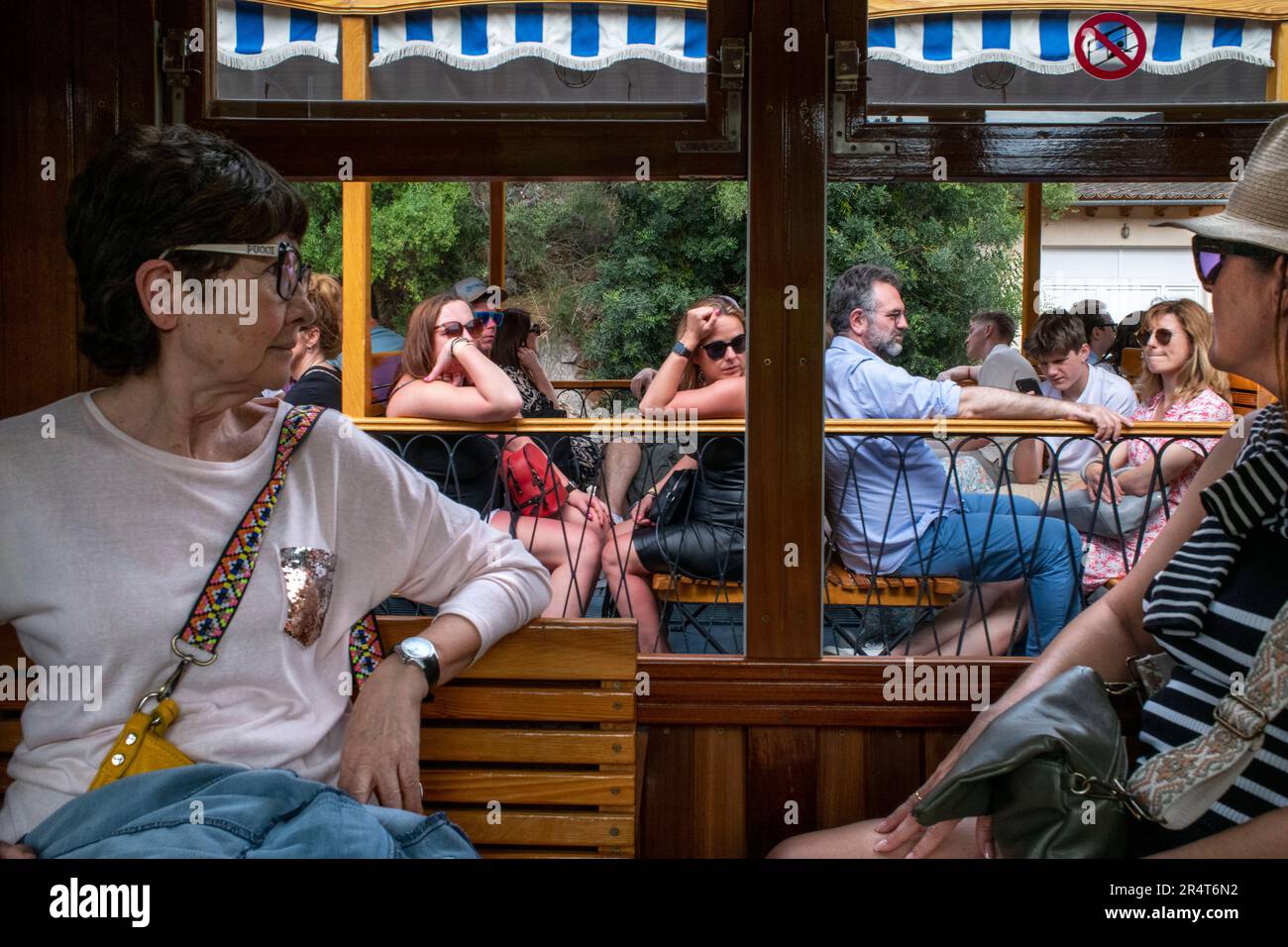 Turisti all'interno del tram d'epoca al centro del villaggio di Soller. Il tram opera un servizio 5kms dalla stazione ferroviaria nel villaggio di Soller al Foto Stock